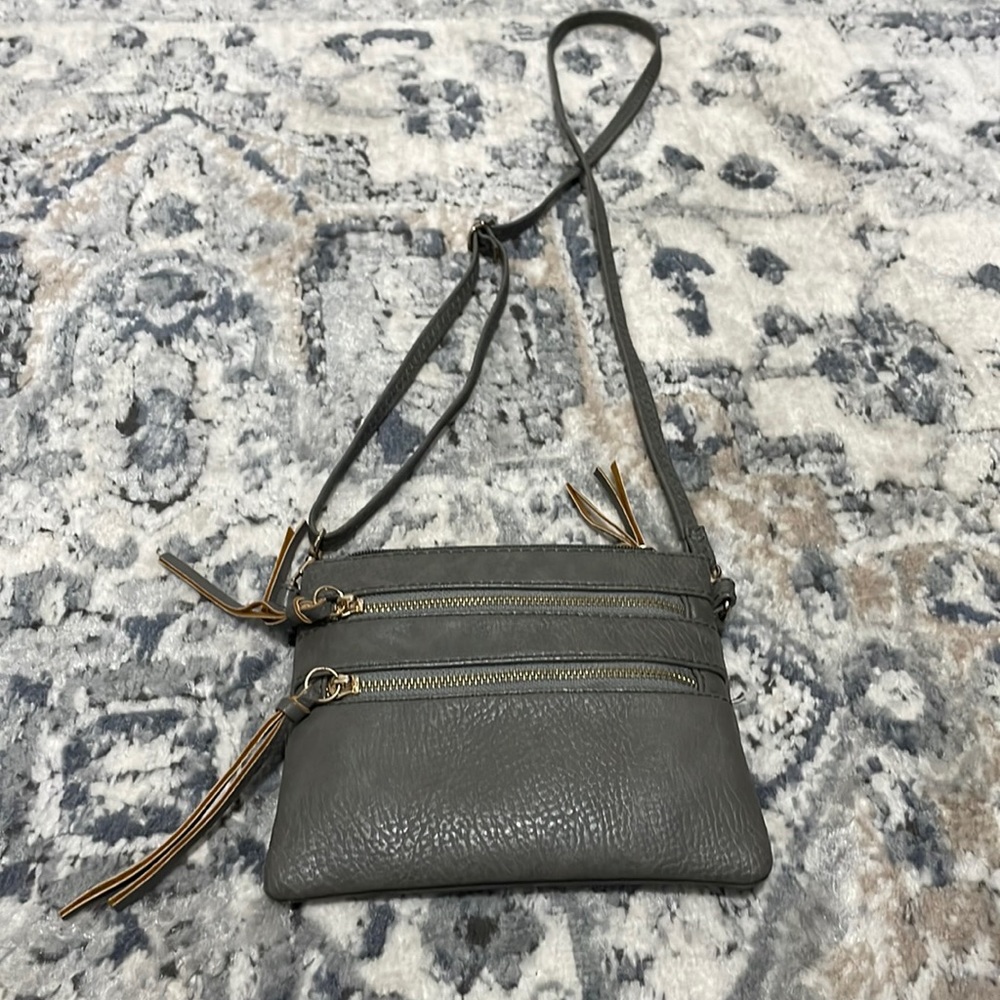 Leather cross body bag.  Dark grey.  3 outside/1 inside zippered pockets.